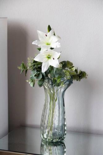 a glass vase with white flowers sitting on a table at Shangri-la Doonside in Kingsburgh