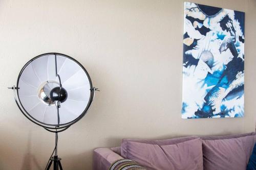 a fan in a living room next to a couch at Shangri-la Doonside in Kingsburgh