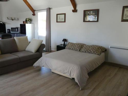 a living room with a bed and a couch at Maison indépendante et privative 52m2 au calme in Cléré-les-Pins