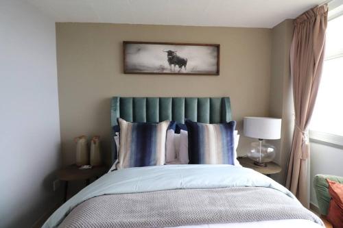 a bedroom with a bed and a picture of a horse at Shangri-la Doonside in Kingsburgh