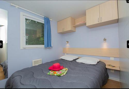 um quarto com uma cama com um chapéu vermelho em Camping St Jean - Moustiers Ste Marie em Moustiers-Sainte-Marie