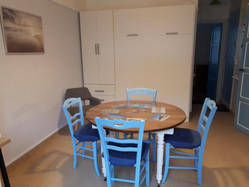 une salle à manger avec une table en bois et des chaises bleues dans l'établissement LA PLAGE, à Berck-sur-Mer