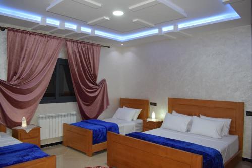 a hotel room with two beds and a window at Moonrise Villa VIP Midelt in Midelt