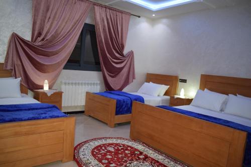 a bedroom with two beds and a window at Moonrise Villa VIP Midelt in Midelt