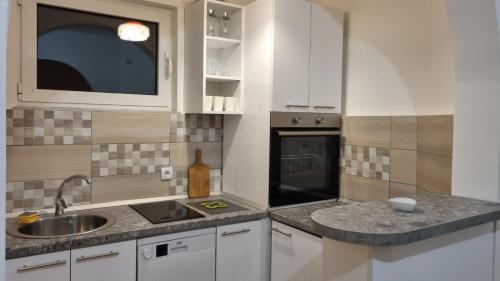 a kitchen with white cabinets and a sink at Apartments near Belgrade Waterfront in Belgrade