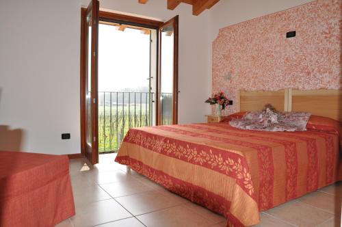 - une chambre avec un lit et une grande fenêtre dans l'établissement Agriturismo ai Ciliegi, à Bardolino
