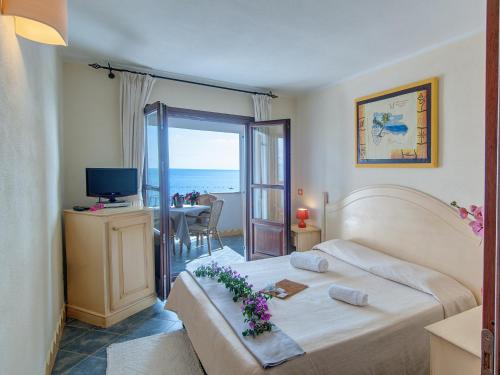 a bedroom with a bed and a view of the ocean at Guest House Dolce Vita in Cala Gonone