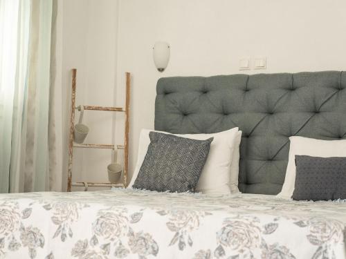a bedroom with a large bed with a gray headboard at Anastasia Mare Studios in Pefkochori