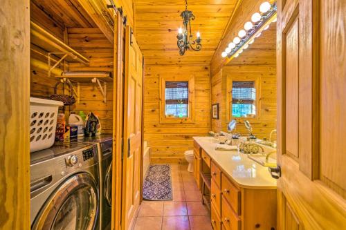 a log cabin kitchen with a washer and dryer at Pet-Friendly Cabot Cabin with Fenced Yard! in Cabot