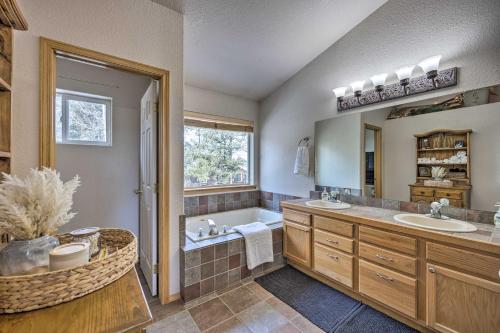 a bathroom with two sinks and a tub and a mirror at Woodland Park Home with Stunning Mountain Views in Woodland Park
