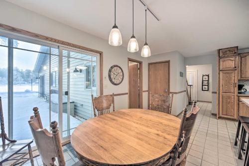 a dining room with a wooden table and chairs at Spacious Home with Deck on Lake Chetek! in Chetek