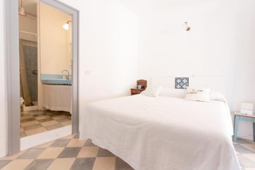 a white bed in a white room with a checkered floor at Le Sette Sorelle in Filicudi