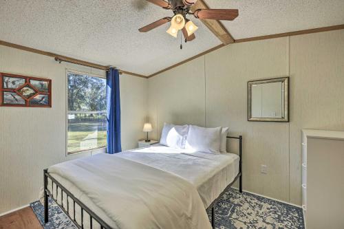 een slaapkamer met een bed, een plafondventilator en een raam bij Ocala Vacation Rental on 14-Acre Working Farm in Ocala
