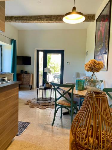 une cuisine et un salon avec une table et des chaises dans l'établissement Le Mas Saint Philippe, à Jonquières