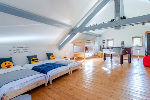 Dos camas en una habitación con mesa de ping pong. en La Bergerie Des Amis, en Ventron