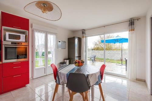 une cuisine avec une table avec un bol de fruits dessus dans l'établissement La Janne - Maison avec jardin, à Saujon