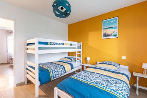 two bunk beds in a room with yellow walls at La Janne - Maison avec jardin in Saujon