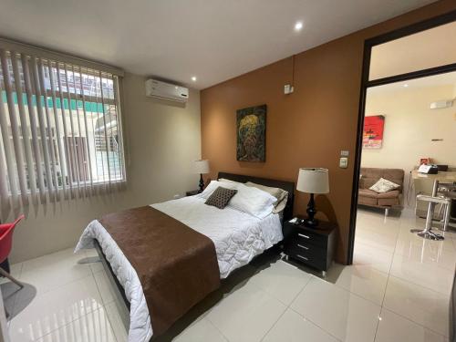 a bedroom with a bed and a couch in it at LOFTSCACAO APARTMENTS, Villas Cacao, near to Playa Bonita Limón in Portete