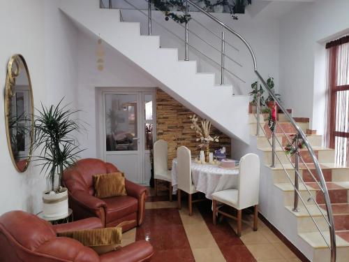 a dining room with a table and chairs and a staircase at Pensiunea Valurile Bistritei in Vatra Dornei