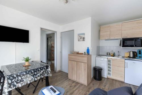 une petite cuisine avec une table dans une pièce dans l'établissement Océania -proche Mer et Thalasso, à Cabourg