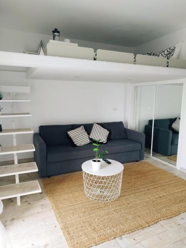 a living room with a blue couch and a loft bed at Sunset, Ocean Views 214 in Playa Paraiso