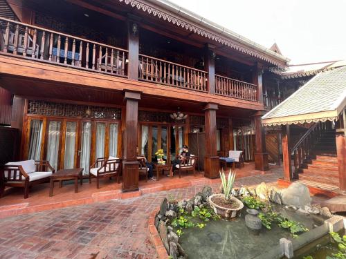 a building with a patio with people sitting at tables at Chaluenxay Boutique hotel in Luang Prabang