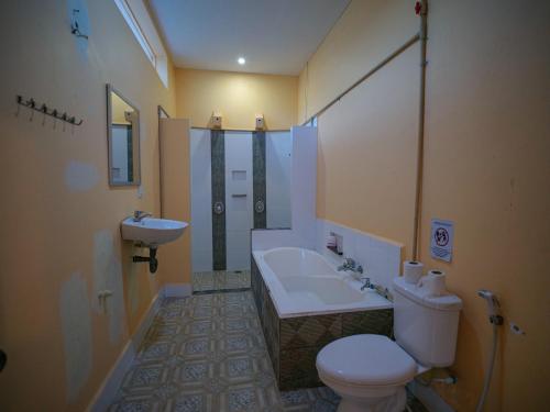 uma casa de banho com uma banheira, um WC e um lavatório. em Villa Kampot Cafe em Kampot