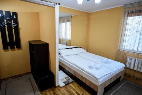 een slaapkamer met een groot bed met witte lakens bij Flower Apartment - Standard in Odorheiu Secuiesc