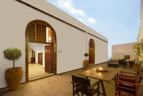 a patio with a wooden table and chairs and a building at AENAON ESTATE 1896 by K&K in Pirgos