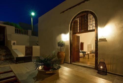 een huis met een open deur en een patio in de nacht bij AENAON ESTATE 1896 by K&K in Pirgos