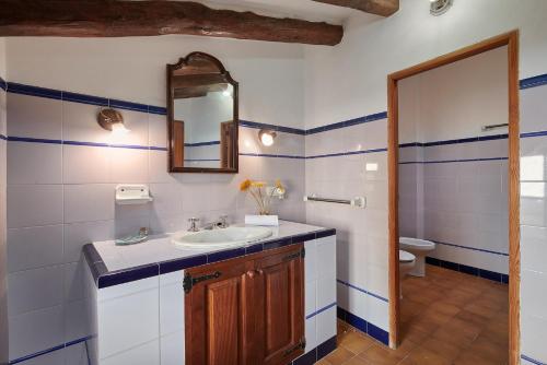 a bathroom with a sink and a mirror and a toilet at Finca Son Oliver by Mallorca House Rent in Felanitx