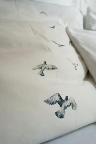 a group of birds flying on a white blanket at Aparthotel Domizil in Borkum