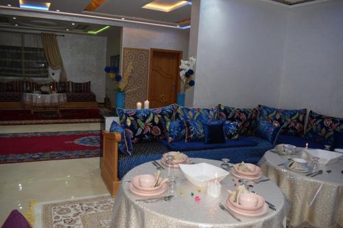 a living room with two tables and a blue couch at Moonrise Villa VIP Midelt in Midelt