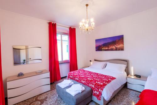 een slaapkamer met een bed met rode gordijnen en een kroonluchter bij Waterfront House in Genua