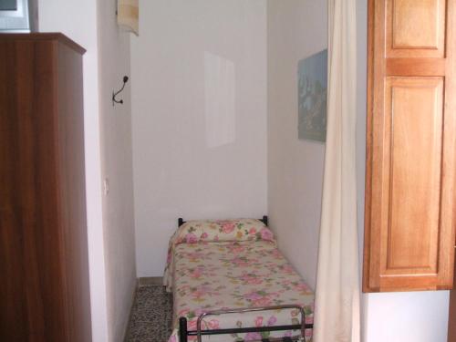 a small room with a small bed in the corner at Su Ghindalu Guesthouse in Villanova Monteleone