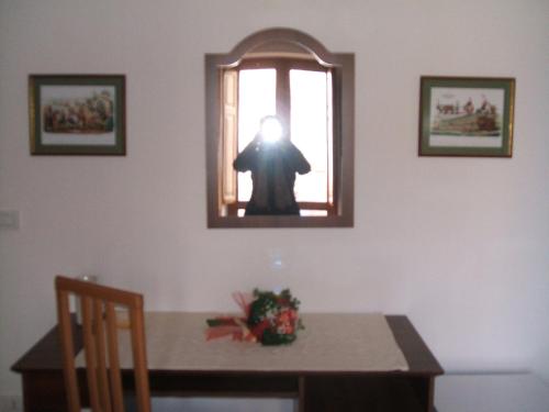 a person taking a picture in a window of a table at Su Ghindalu Guesthouse in Villanova Monteleone