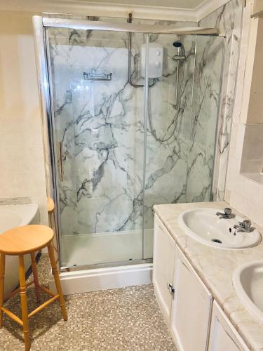 a bathroom with a shower and a sink at Field Cottage in Whittlesey