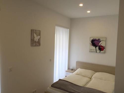 a white bedroom with a bed and a window at NEW Apartment - 10 min DOWNTOWN in Vienna