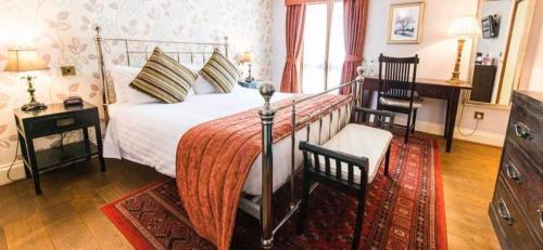 a bedroom with a bed and two chairs in it at The Bubble Inn Hotel in Derby