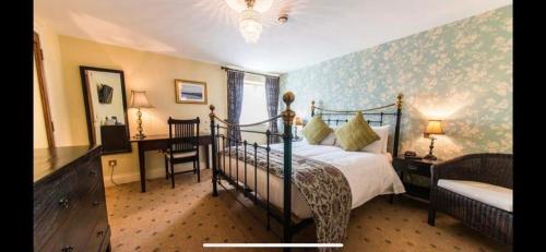 een slaapkamer met een bed, een bureau en een stoel bij The Bubble Inn Hotel in Derby