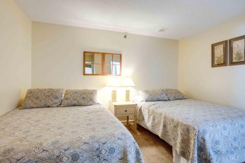 um quarto com 2 camas e uma mesa com um candeeiro em Marylander Condominiums, 90 steps from the beach em Ocean City