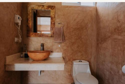 a bathroom with a wooden bowl sink and a toilet at habitaciones Mi Viejo Chit in Holbox Island