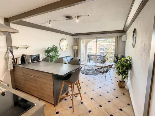 a kitchen and living room with a table and chairs at Port Marine - T3 calme, avec terrasse, piscine, près de la plage in Sainte-Maxime