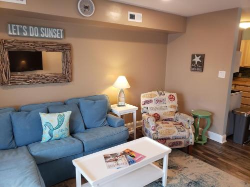 a living room with a blue couch and a chair at Marylander Condominiums, 90 steps from the beach in Ocean City
