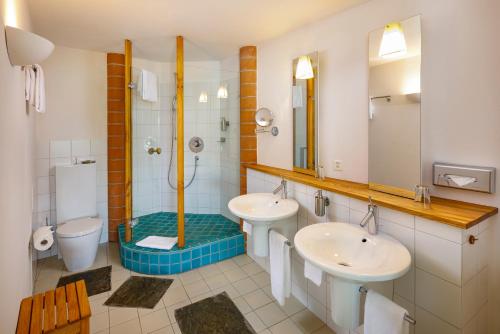 a bathroom with two sinks and a shower at Hotel Restaurant Schiff in Pfäffikon