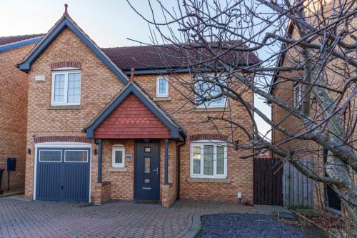 a brick house with a blue garage at Redgrave Detached home with free parking 4 minutes from City Walls in York