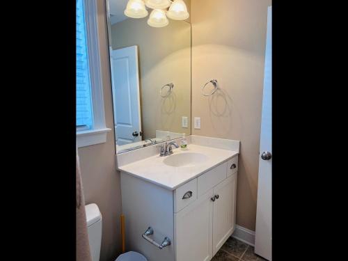 a bathroom with a sink and a mirror at 2 the C in Holden Beach