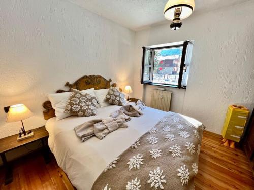 a bedroom with a large white bed with blankets and pillows at Chalet le Pigne Gressoney Saint Jean in Gressoney-Saint-Jean