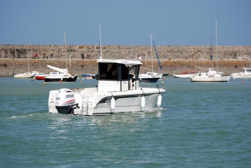a small white boat floating in the water at Studio Castel Binic in Pordic