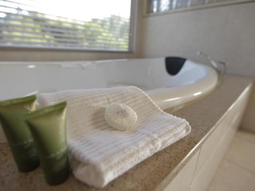 a bathroom with a white bath tub and a towel at At The Gap Holiday Home in Halls Gap